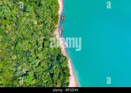 (Vista da sopra) stupefacente vista aerea di una costa verde di un'isola tropicale con alcune tradizionali barche da pesca in Nam Ngum serbatoio. Foto Stock