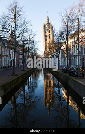 La torre pendente della Oude Kerk chiesa, noto anche come Oude Jan o Scheve Jan, riflette in Oude Delft canal a Delft, Paesi Bassi. Foto Stock