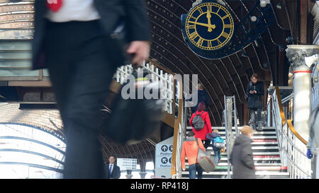 Imprenditore passando orologio stazione correre per prendere il treno presso la stazione ferroviaria di York Regno Unito Foto Stock