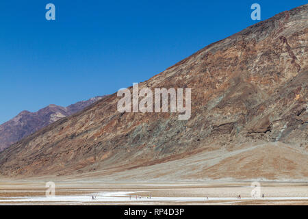 I visitatori a piedi attraverso salina nel bacino Badwater, il punto più basso nel Parco Nazionale della Valle della Morte, California, Stati Uniti. Foto Stock