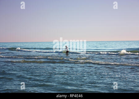 Uomo immerso nella pesca in mare e raccoglie tellines o vongole o altri frutti di mare su una giornata invernale Foto Stock