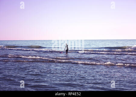 Uomo immerso nella pesca in mare e raccoglie tellines o vongole o altri frutti di mare su una giornata invernale Foto Stock