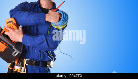 Sfondo con elettricista in uniforme con strumenti e apparecchiature elettriche e sfondo blu. vista frontale di dettaglio. Foto Stock