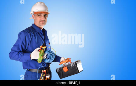 Elettricista in uniforme in tuta blu e le protezioni di sicurezza e strumenti di colore blu sul gradiente dello sfondo isolato. Vista frontale. Foto Stock