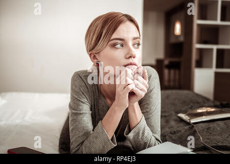 Attraente giovane imprenditrice pensieroso indossa bellissimi orecchini Foto Stock