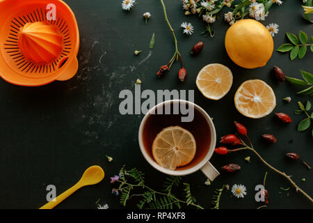 Rosa canina tisana laici flat top view con fettina di limone sul tavolo di legno Foto Stock