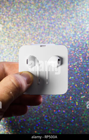 Parigi, Francia - Ott 2, 2018: uomo con una nuova prima unboxing Apple cuffie EarPod imballate in estetica confezione di cartone Foto Stock