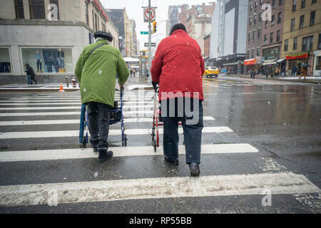 Le donne anziane con loro walkers nel quartiere di Chelsea di New York manovra attraverso la neve su Mercoledì, 20 febbraio, 2019. Un inverno meteo advisory è in effetti come la neve le transizioni per un mix di nevischio e pioggia e infine tutti i pioggia da 1AM giovedì depositare 2-4 pollici. (Â© Richard B. Levine) Foto Stock