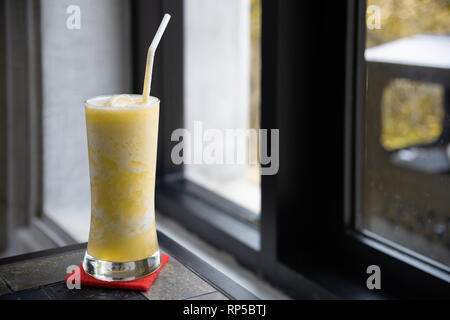 Bicchieri di succo di ananas sulla tabella classica con finestra spia Foto Stock