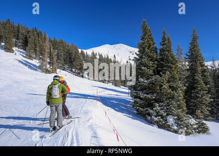 Due gli sciatori a piedi lungo la neve del Colorado Montagne Rocciose a Copper Mountain Ski Resort in inverno Foto Stock
