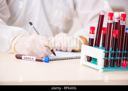 Bel giovane assistente di laboratorio test di campioni di sangue in ospedale Foto Stock