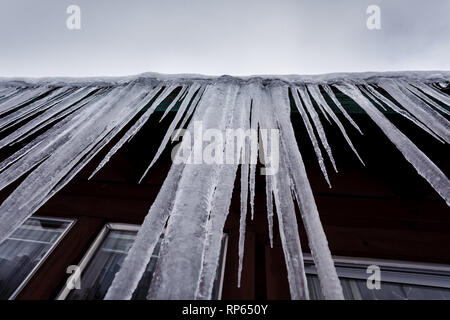 Decorazione invernale del tetto nel primo piano del lago Tahoe lungo ghiaccioli appesi al bordo del tetto Foto Stock