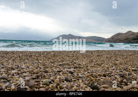 Grandi onde nel mare e spiaggia ghiaiosa Foto Stock