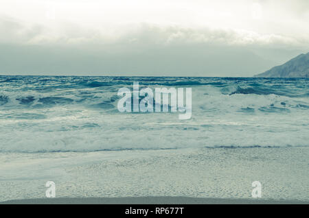 Le onde spumeggianti in mare e spiaggia ghiaiosa Foto Stock