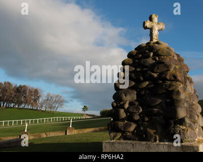 Nuova Zelanda guerre memorial cairn, Waihi cimitero, South Taranaki, Nuova Zelanda. Waihi Redoubt era situato vicino agli alberi all'orizzonte. Foto Stock