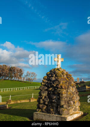 Nuova Zelanda guerre memorial cairn, Waihi cimitero, South Taranaki, Nuova Zelanda. Waihi Redoubt era situato vicino agli alberi all'orizzonte. Foto Stock