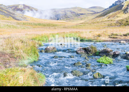 Hveragerdi Hot Springs nel fiume Reykjadalur giorno mattina nel sud dell'Islanda Golden Circle con valvola di sfiato del vapore fumarola il paesaggio e la nebbia di vapore Foto Stock