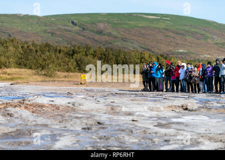 Haukadalur Valley, Islanda - 19 Settembre 2018: Geyser paesaggio con gruppo di persone in attesa in sud paese islandese da Strokkur Geysir Hot Springs Foto Stock