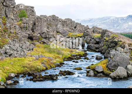 Thingvellir Parco Nazionale con fogliame di autunno in Islanda Golden Circle e una piccola cascata sul sentiero roccioso con colore blu acqua paesaggio Foto Stock