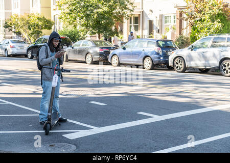 Washington DC, Stati Uniti d'America - 12 Ottobre 2018: uomo su scooter e giacca riding il pendolarismo per lavoro su strada in città Foto Stock
