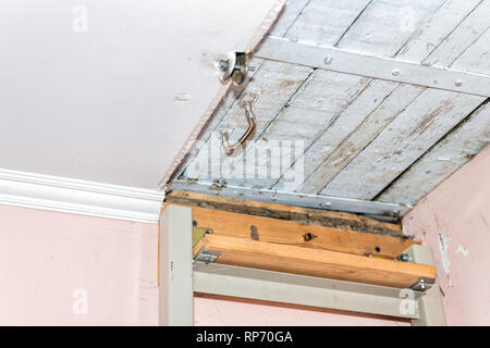 Primo piano della scaletta che porta a porta chiusa Chiusura per mansarda con soffitto in legno nel retro vintage dacha cottage casa nella campagna del paese Foto Stock