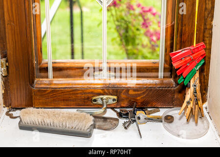 Primo piano della finestra rustico con verde rosso clothespins in legno per appendere gli abiti in estate nel rustico paese retrò home dacha in Ucraina o in Russia con Foto Stock