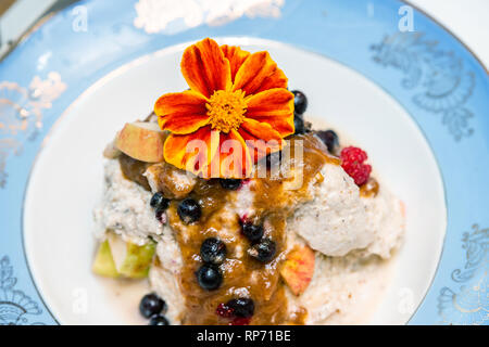 In casa materie vegane gelati insalate e frutta fresca da giardino sulla piastra davanzale con sciroppo di data topping e giallo arancione calendula fiori commestibili Foto Stock