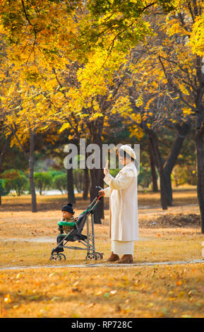 Giovane madre con i bambini nel parco. Foto Stock