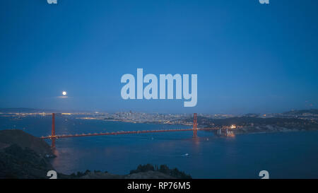 La luna piena sorge dietro il Golden Gate bridge di san francisco Foto Stock