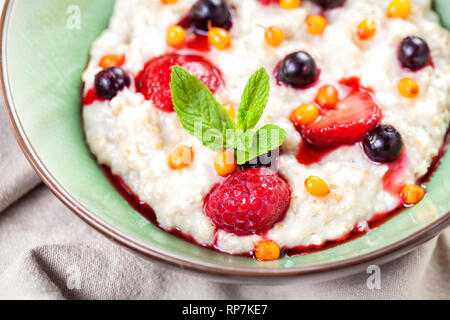 Porridge con estate fresca le bacche e le foglie di menta vicino fino al ristorante Foto Stock