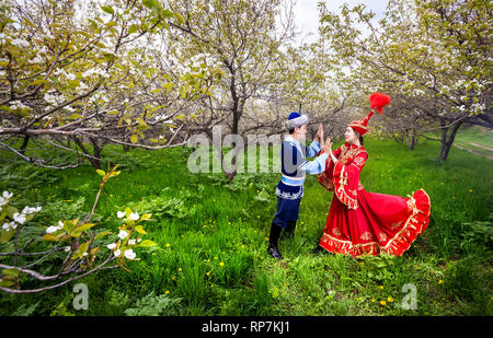 Matura in kazako costume tradizionale in fioritura primaverile apple giardino di Almaty in Kazakistan e in Asia centrale Foto Stock