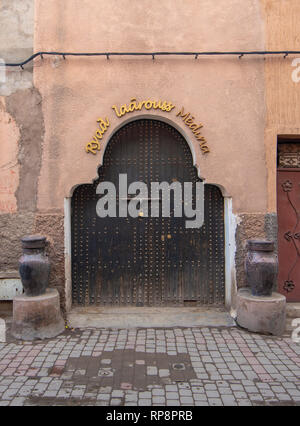 Stile tradizionale marocchino progettazione di un legno antico riad entrata porta. Nella vecchia Marrakech, Marocco. Tipico, vecchio, marrone intricate sculture, studded Foto Stock