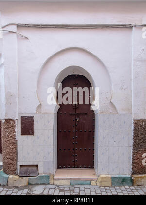 Stile tradizionale marocchino progettazione di un legno antico riad entrata porta. Nella vecchia Marrakech, Marocco. Tipico, vecchio, marrone intricate sculture, studded Foto Stock