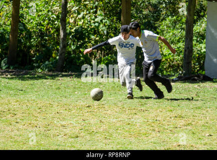 Ragazzi adolescenti play futbol (calcio) nel sole di mezzogiorno in Perù. Foto Stock