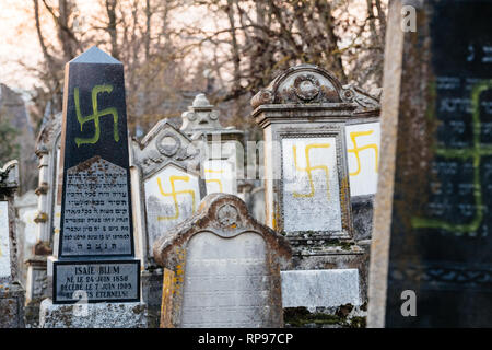 Soggetto ad atti vandalici tombe con svastica simboli nazisti in giallo spray-dipinte sulle tombe danneggiato - Cimitero Ebraico in Quatzenheim vicino a Strasbourg Foto Stock