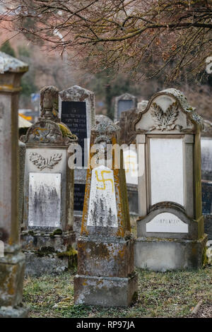 Soggetto ad atti vandalici tombe con simboli nazisti in giallo spray-dipinte sulle tombe danneggiato - Cimitero Ebraico in Quatzenheim vicino a Strasbourg Foto Stock