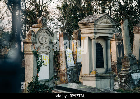 Soggetto ad atti vandalici tombe con svastiche simboli nazisti in giallo spray-dipinte sulle tombe danneggiato - Cimitero Ebraico in Quatzenheim vicino a Strasbourg Foto Stock