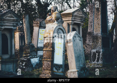 Soggetto ad atti vandalici tombe con svastiche simboli nazisti in giallo spray-dipinte sulle tombe danneggiato - Cimitero Ebraico in Quatzenheim vicino a Strasbourg Foto Stock