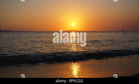 Brillante tramonto con sole giallo sotto la superficie del mare - vacanze estive e viaggi natura adventure concept. Foto Stock