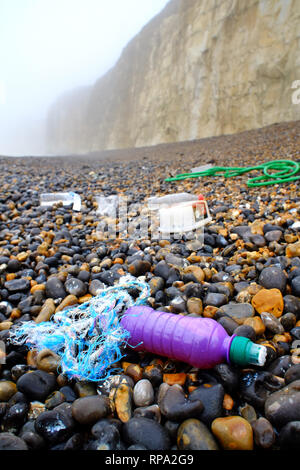 Lavato in plastica fino a una spiaggia di ciottoli, Newhaven, East Sussex. Foto Stock