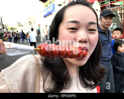 Pechino, Cina. Xxv Sep, 2018. Una donna cinese mangia un popolare, di zucchero frutta smaltata stick in centro a Pechino il 25 settembre 2018. Il mantenimento della Cina di crescita costante è sempre più difficile in mezzo a significativi cambiamenti e sfide con i continui conflitti commerciali con gli Stati Uniti, secondo la Premier LI Keqiang. Importazioni di prodotti agricoli da parte degli Stati Uniti sono tra i molti obiettivi per le tariffe. Credito: Todd Lee/ZUMAprilESS.com/ZUMA filo/Alamy Live News Foto Stock