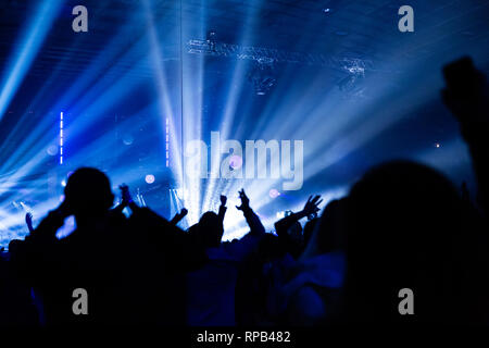 Concerto folla si divertono a un concerto rock. Grande sala da concerto con un grande palco. Un sacco di gente. Attrezzature di fulmini. Ripresa televisiva a un concerto o Foto Stock