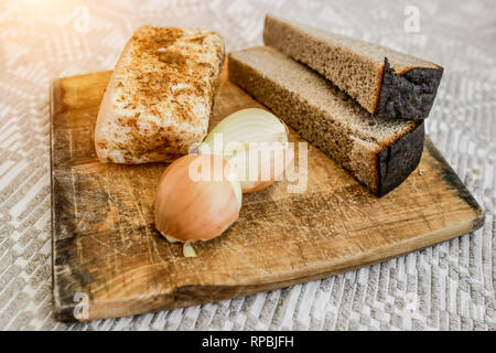In casa di strutto, pane e cipolle sul tagliere. Cucina nazionale. Foto Stock
