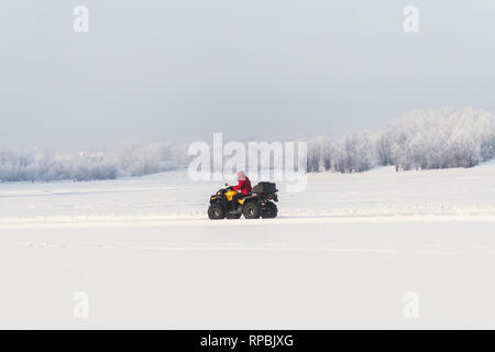 Veicolo fuoristrada in moto in inverno giornata di sole. Unidentified motocross rider su quad bike in apertura di stagione di motocross gara. inverno motocross. Foto Stock