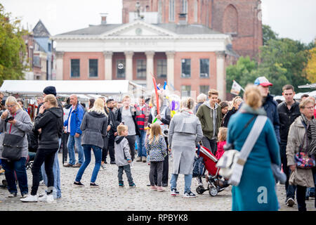 Mercato del sabato mattina a Groningen su un giorno nuvoloso con in mezzo alla folla un giovane uomo vendita di animali di palloncino che egli fa in loco Foto Stock