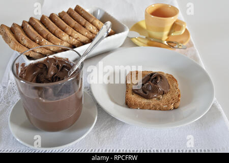 Fette biscottate con crema di nocciole al cacao con bicchiere da sopra Foto Stock
