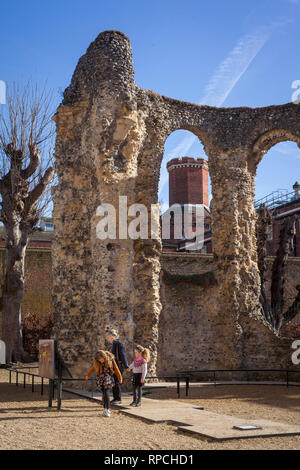 Una madre e i suoi due figli di visitare le rovine della abbazia di lettura con la lettura di prigione dietro. Foto Stock