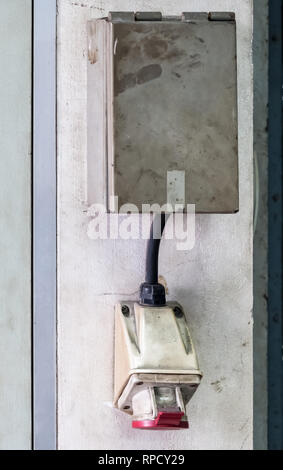 Principali presa elettrica con la scatola di metallo sulla parete in cemento per uso nella vecchia fabbrica. Foto Stock
