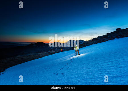 Alpinista passeggiate sulla neve con msnowdon in background Foto Stock