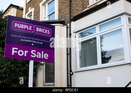 Un viola mattoni " per la vendita " segno al di fuori di una proprietà a londra Foto Stock